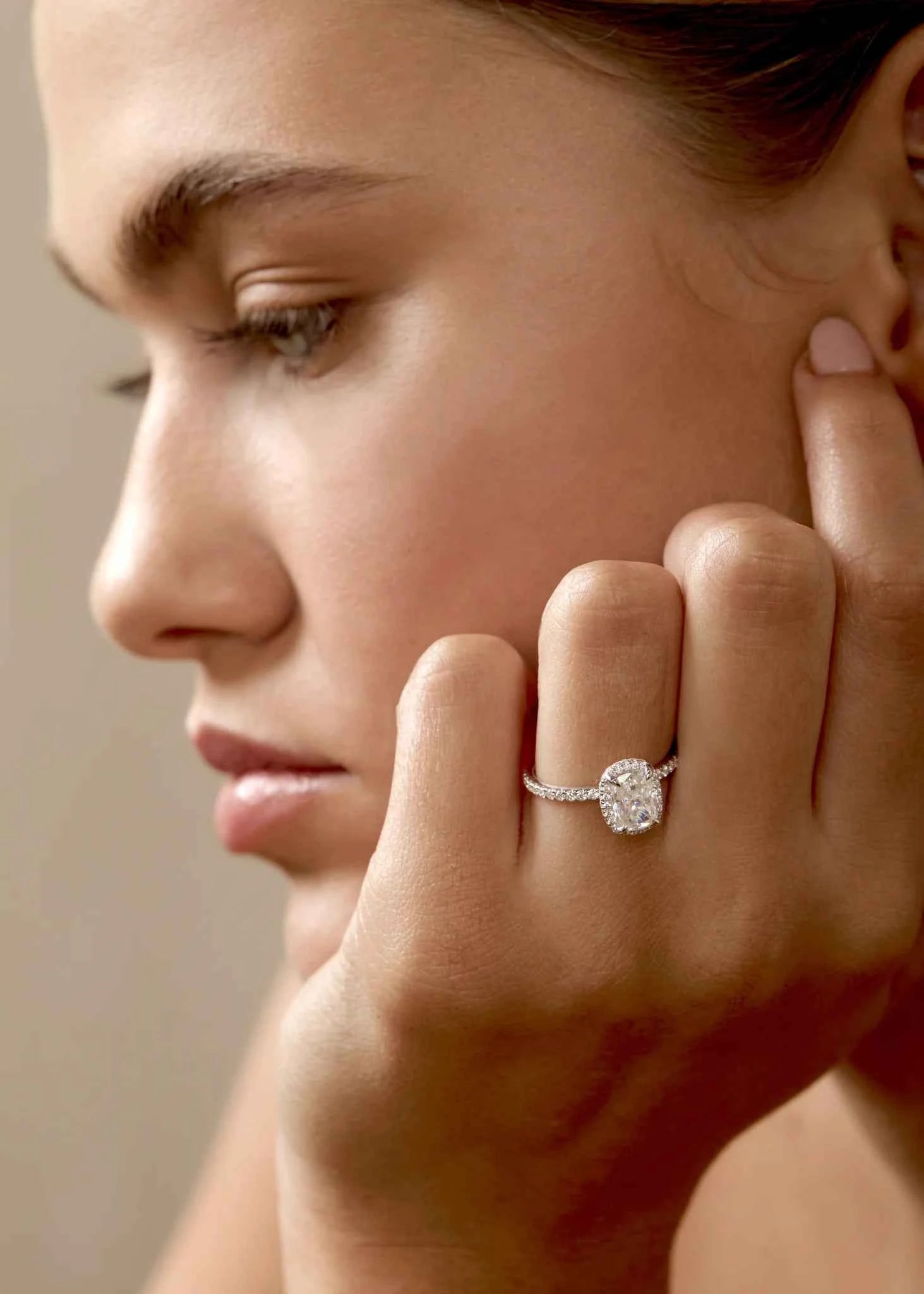 Close-up of a woman wearing a moissanite ring on her finger.