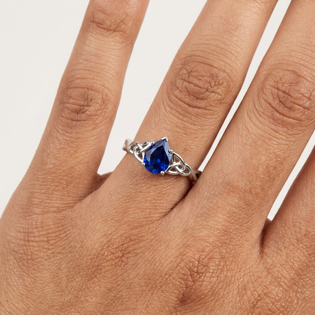 Pear-Shaped Blue Sapphire Celtic Knot Engagement Ring With Hand