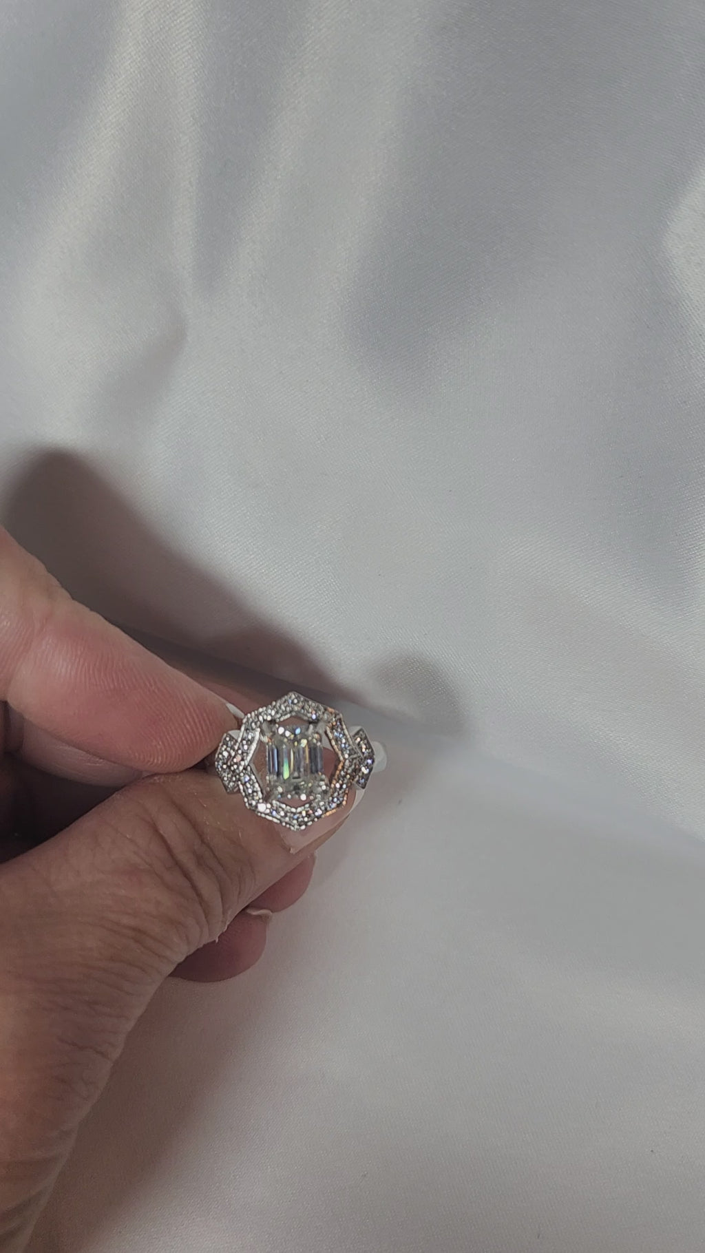 2ct Emerald Cut Moissanite ring enhanced by moissanite halo setting.